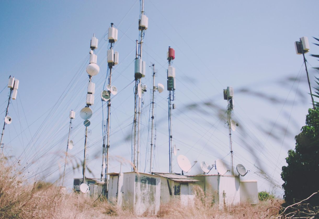 Multiple communication towers in rural field.